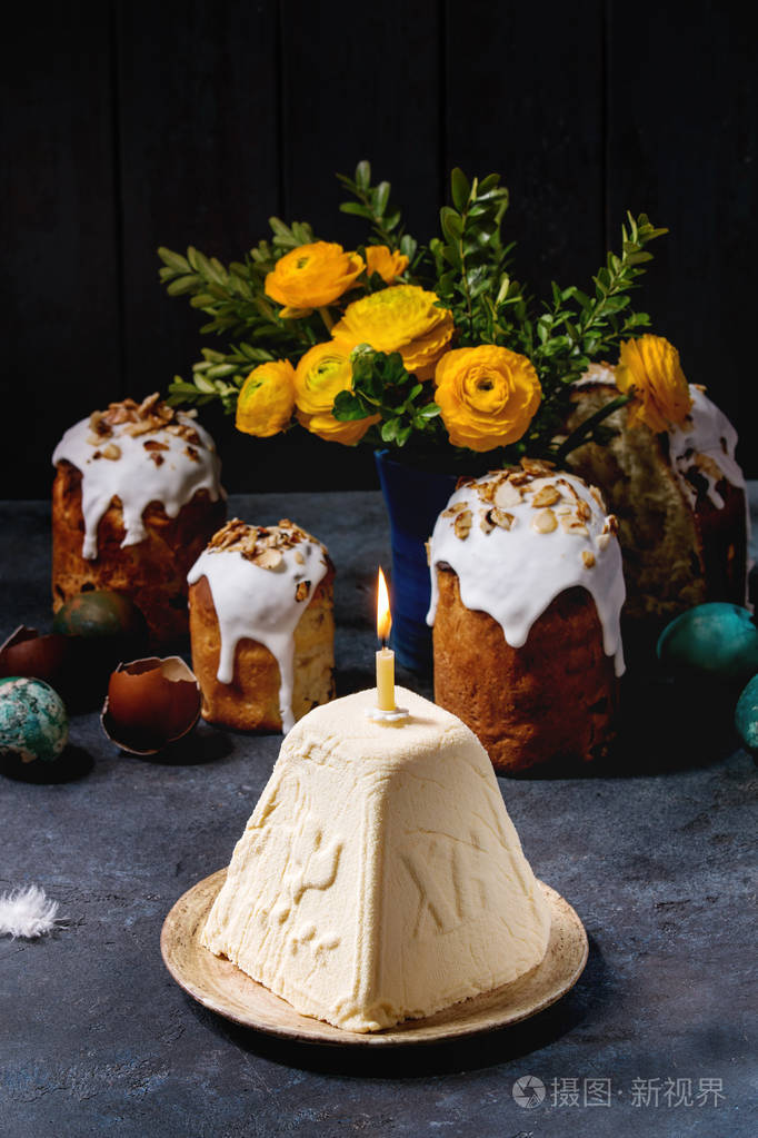 传统的俄罗斯复活节家庭奶酪甜点正统帕斯卡与燃烧的蜡烛站在陶瓷盘子