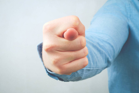 用拳头和拇指在指针和中指之间做手势通常带有粗俗的意思照片