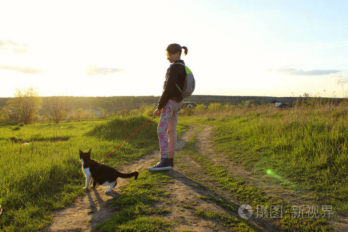 年轻的少女和她的燕尾服猫散步主人和宠物在户外儿童动物宠物旅行的