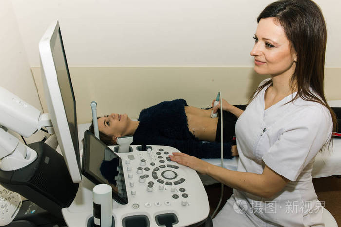 年轻漂亮的医生女人在一个超声波年轻女孩的帮助下对内脏进行体检