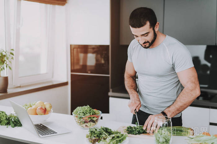 一个运动男子正在为早餐准备沙拉. 烹饪理念.健康的生活方式.