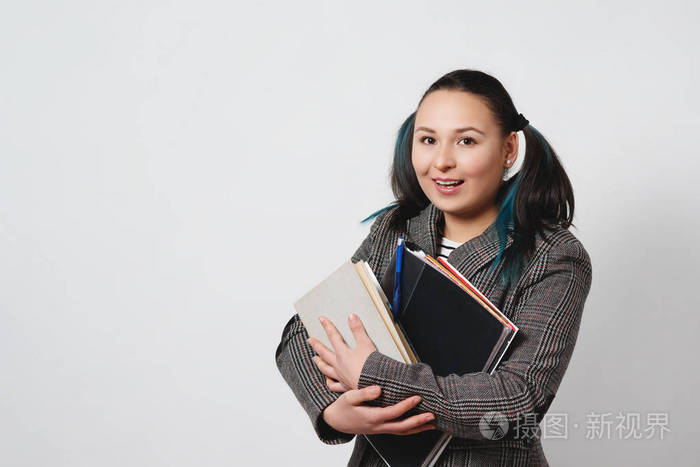 自信的年轻学生妇女拿着书和文件夹的肖像.