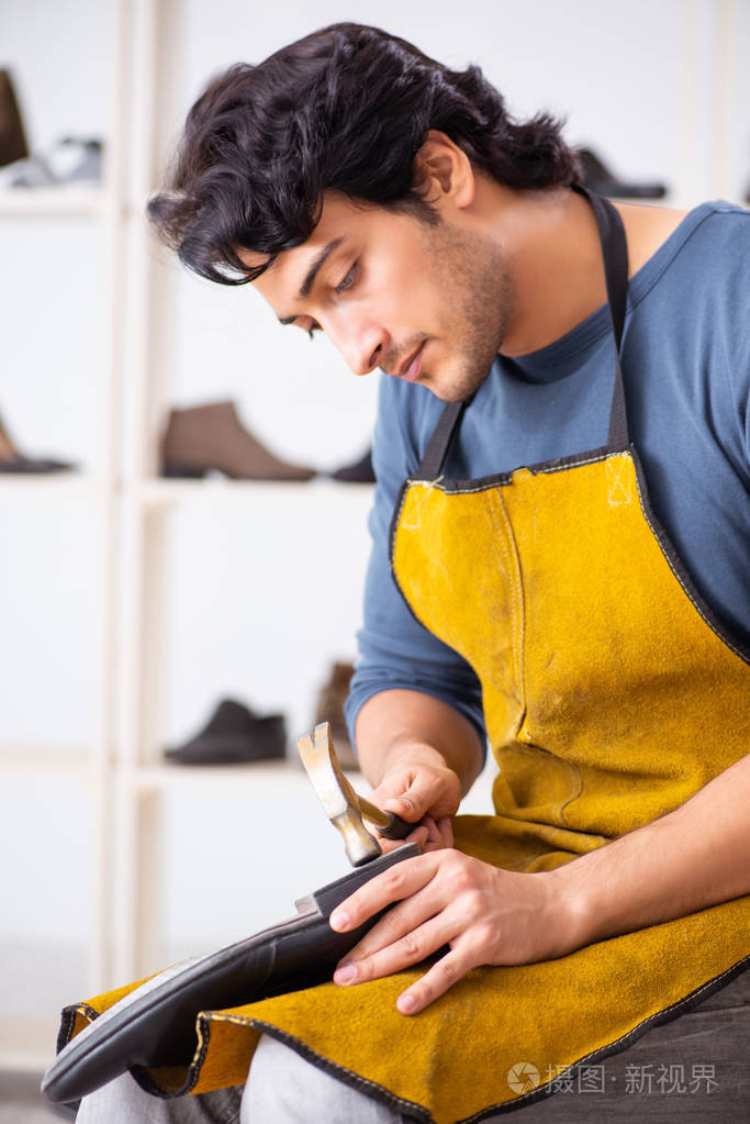 在车间修鞋的年轻人