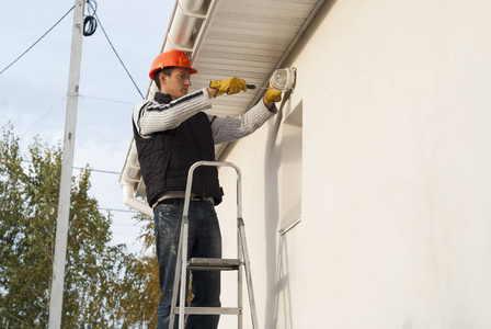 手里拿着螺丝刀的电工安装了一盏壁灯照片