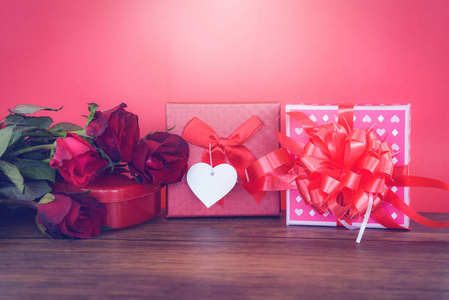 情人节礼品盒红色和粉红色的木材背景情人节红色玫瑰花红色的心爱的概念和礼品盒彩带弓在红色的背景