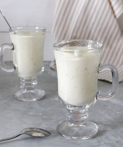 新鲜混合猕猴桃蛋白冰沙与酸奶或牛奶在玻璃瓶健康饮食白色木制背景与