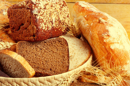 黑麦面包和小麦粉在木桌上的柳条中粗磨