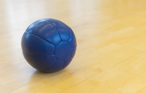 木制地板上的蓝色药物重量球。 交叉球