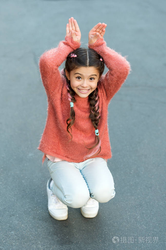 复活节快乐.假日兔子女孩摆姿势像兔子灰色的背景.