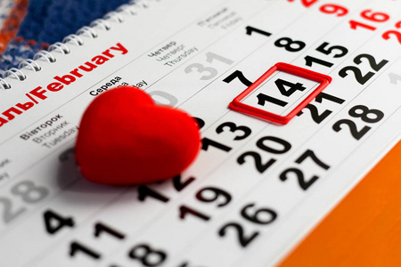 日历上有红色标记的2月14日。 红心装饰。 情人节概念