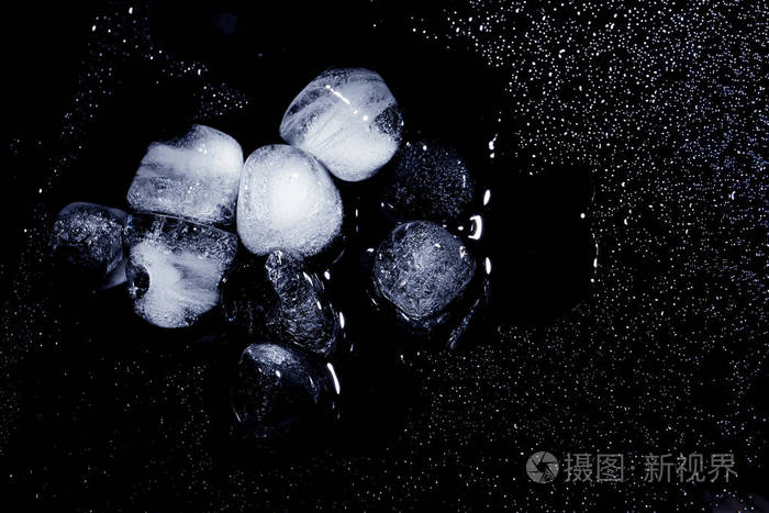 融化冰块和水滴在黑色背景顶部视图文本空间