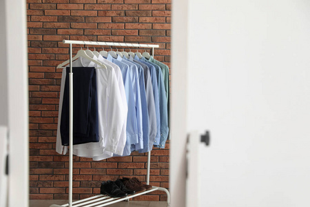 s clothes near brick wall in mirror at home. Space for text