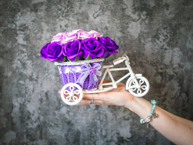 节日花卉装饰 一个小的装饰篮子, 形状为叉子, 灰色背景上有紫色花蕾