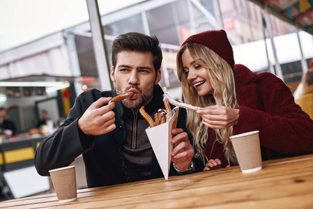 在街头食品市场上, 一对年轻夫妇的特写镜头正在吃教堂