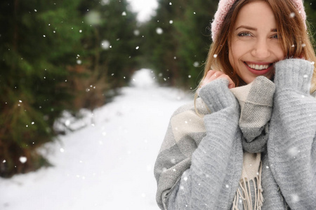 年轻的女人在雪地针叶林空间为文字。 寒假