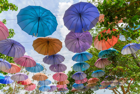 多种颜色的雨伞，蓝天背景装饰在公园里。夏季节日