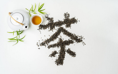 中国传统汉字书法茶是用茶藏在白色织物表面，有茶壶茶杯和茶叶的茶具。