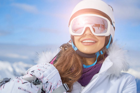 女滑雪者站在雪地上看着摄像机。 冬季背景