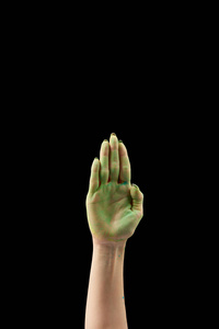 从女人的角度看，她的手掌上有绿色的冬青粉，被隔离在黑色上