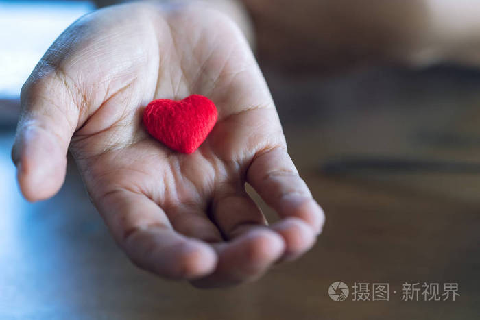 老年女性双手赋予小红心的爱与关怀理念