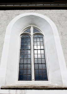 天主教堂正面的旧哥特式窗户。 晴天拍摄的图像