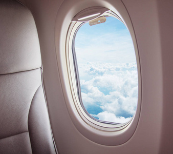 飞机内部有云的窗口视图。 旅行和空运概念