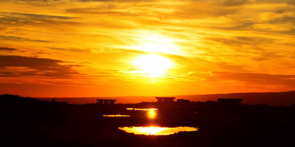 阳光橙美丽的橙黄色日落,阳光低照在天空中,在轻微的阴霾中照片