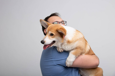 抱着狗的图片成年男子抱着科吉狗照片