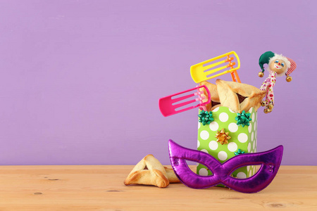 Purim庆祝概念犹太狂欢节假日，木制桌子和紫色背景
