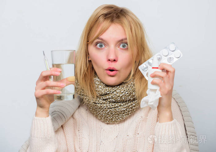 喝大量的液体.女孩吃药来退烧.破热的概念.头痛和发烧的治疗方法.