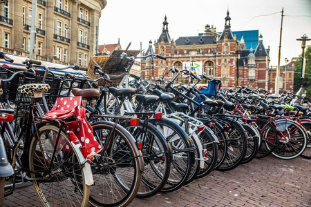 阿姆斯特丹沿街自行车景观，背景是历史悠久的斯塔德斯乔夫堡大厦