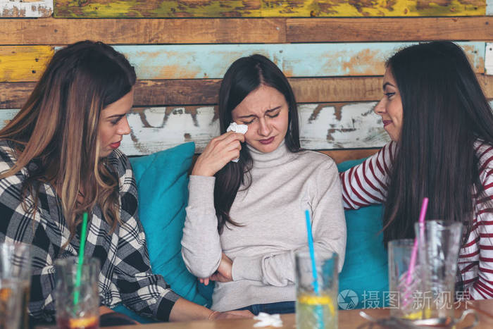 朋友支持和安慰哭泣的年轻女性友谊概念与年轻的千禧女孩在餐厅谈论