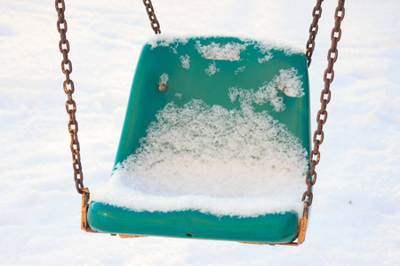 s Playground in winter, swings and carousels under the snow on S