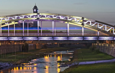 奥斯特拉维西河上的LED灯光桥，在夜晚的蓝色钟声中倒映在奥斯特拉瓦市，钟楼在背后