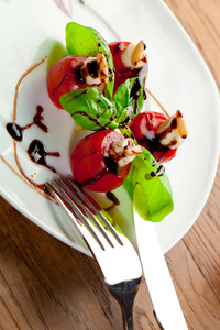 美味的樱桃西红柿，有马拉和罗勒叶，白色盘子