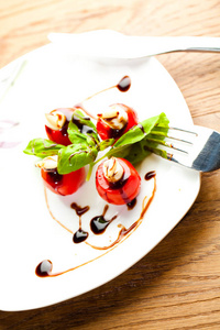 美味的樱桃西红柿，有马拉和罗勒叶，白色盘子