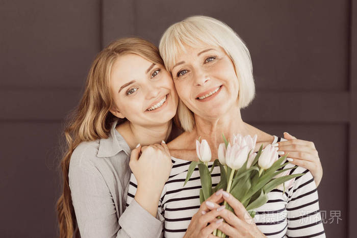 母亲节快乐女儿和妈妈与鲜花在家里