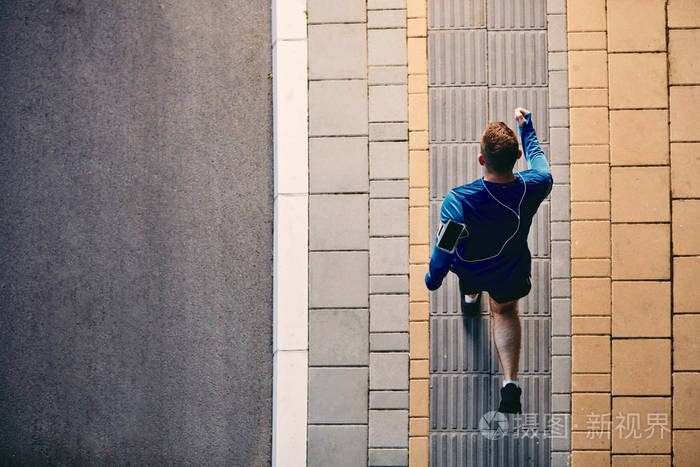 街上奔跑的人的俯视图在手臂智能手机上健康的生活方式概念