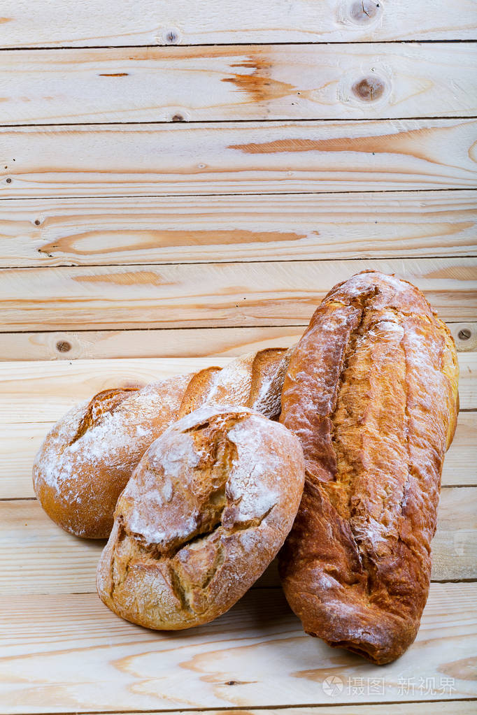美味的法国面包在乡村木制棕色桌子上面包和面粉健康及饮食概念