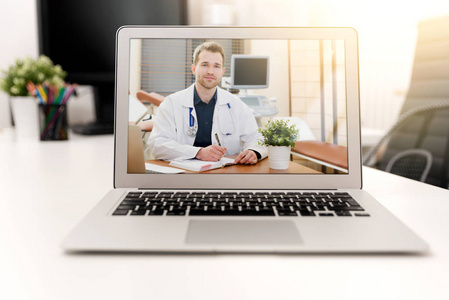 医生在电脑笔记本电脑屏幕上有听诊器。 远程医疗或远程健康概念。
