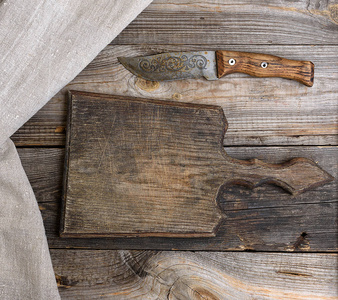 非常旧的木制厨房板和老式刀在灰色的木制背景顶部视图。