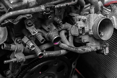 发动机的特写，油门，雷达。发动机故障粉红色防冻液从一辆旧汽车的马达管中流出