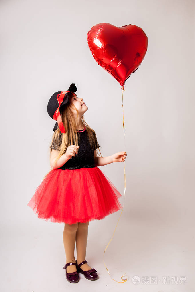 快乐的小女孩与红色气球情人节的概念.