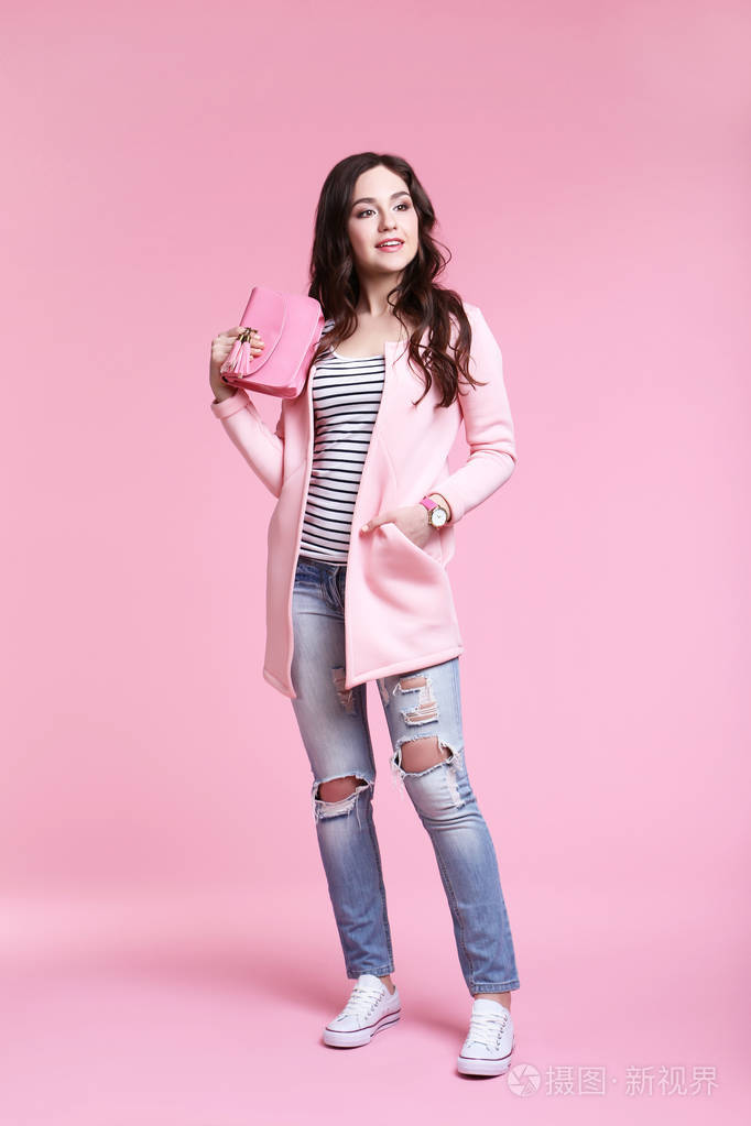 穿着粉色背景时装的美女