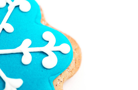 饼干呈蓝色雪花状，咬在白色上。 圣诞节假日装饰冬季食品背景。