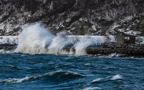 冬季风暴越过Trondheimsfjorden，在海岸上破浪前进..