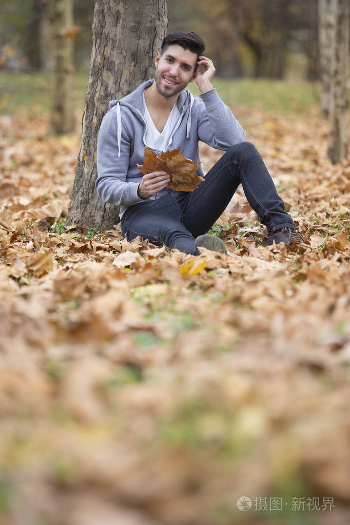 大自然中的英俊男子抱着秋叶复制空间