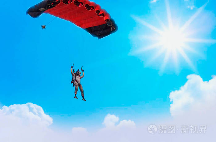 带着红色降落伞降落在蓝天上的降落伞