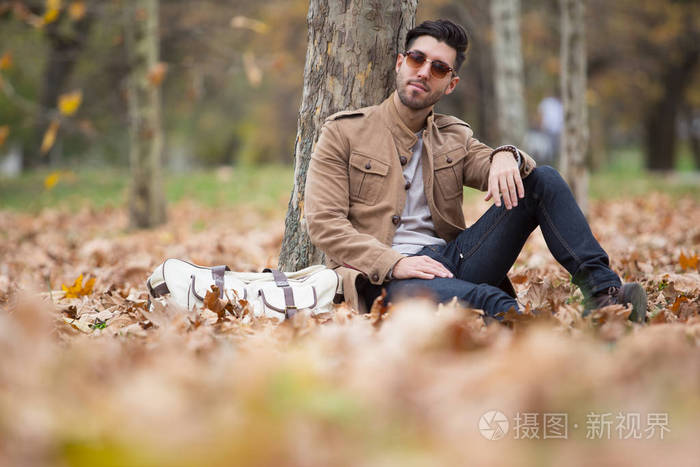 年轻的成年男子英俊的摆姿势在树林里冬天秋天白天