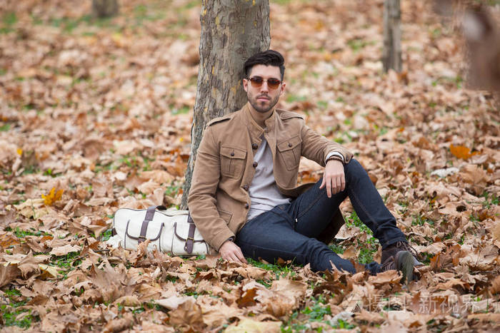 年轻的成年男子英俊的摆姿势在树林里冬天秋天白天